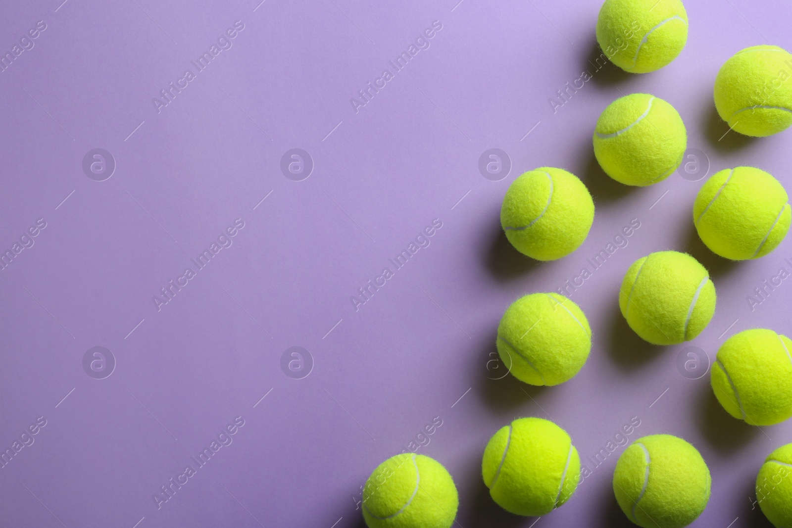 Photo of Tennis balls on violet background, flat lay. Space for text