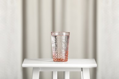 Glass of pure water on white table indoors. Space for text