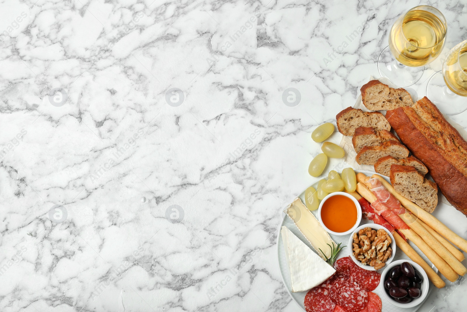 Photo of Flat lay composition with wine, snacks and space for text on marble background