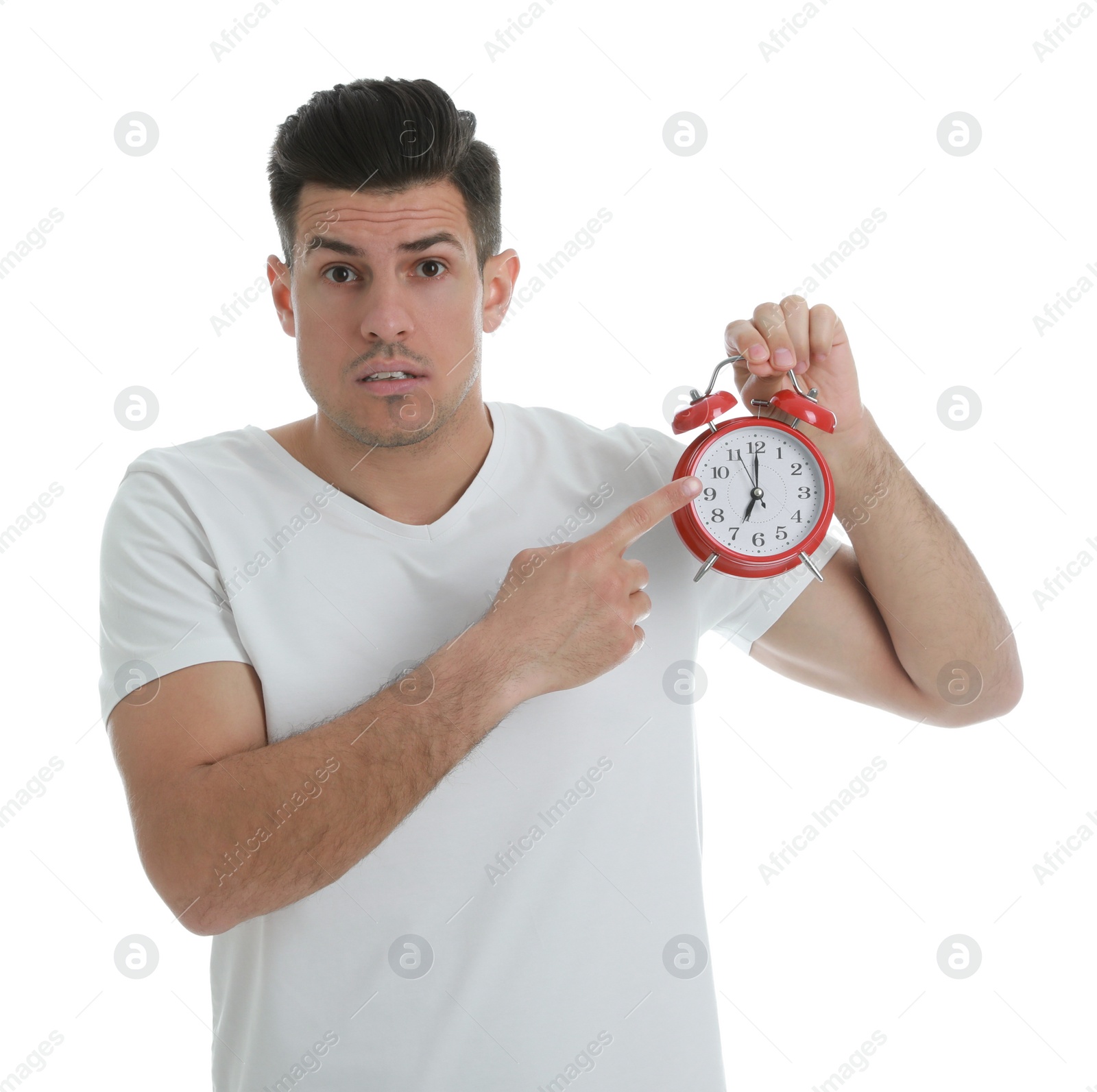 Photo of Emotional man with alarm clock on white background. Being late because of oversleeping