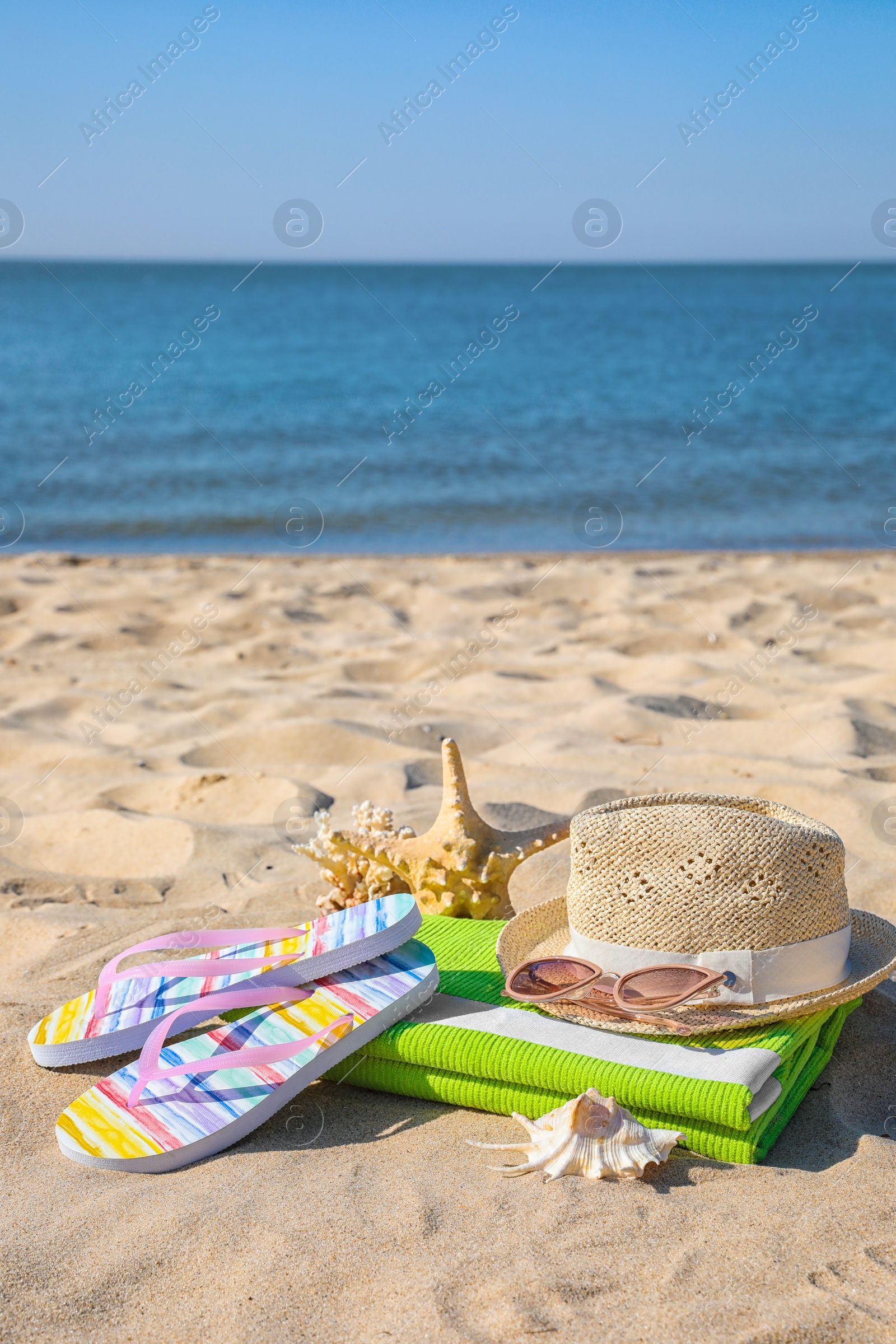 Photo of Set with stylish beach accessories on sand near sea