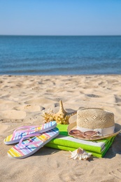 Set with stylish beach accessories on sand near sea