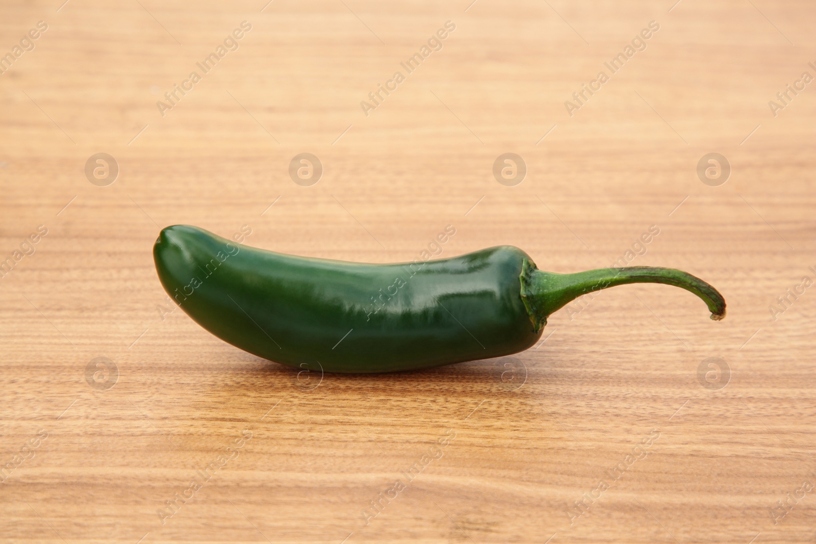 Photo of Fresh green jalapeno pepper on wooden table, closeup