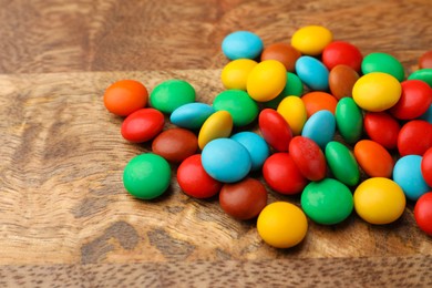 Photo of Tasty colorful candies on wooden table, closeup