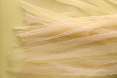 Beautiful tulle fabric on yellow background, top view