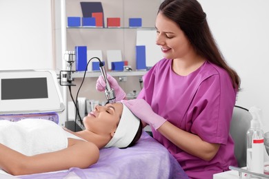 Photo of Young woman undergoing cosmetic procedure in beauty salon. Microcurrent therapy
