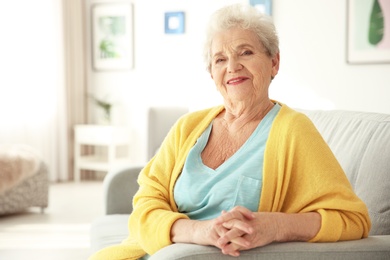 Photo of Elderly woman sitting on couch in living room