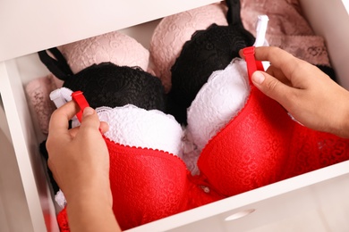 Woman taking bra out of drawer, closeup. Stylish underwear