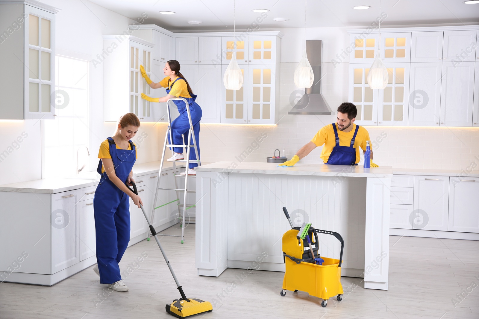 Photo of Team of professional janitors cleaning modern kitchen