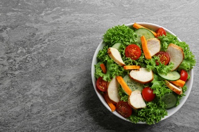 Photo of Delicious fresh chicken salad served on grey table, top view. Space for text
