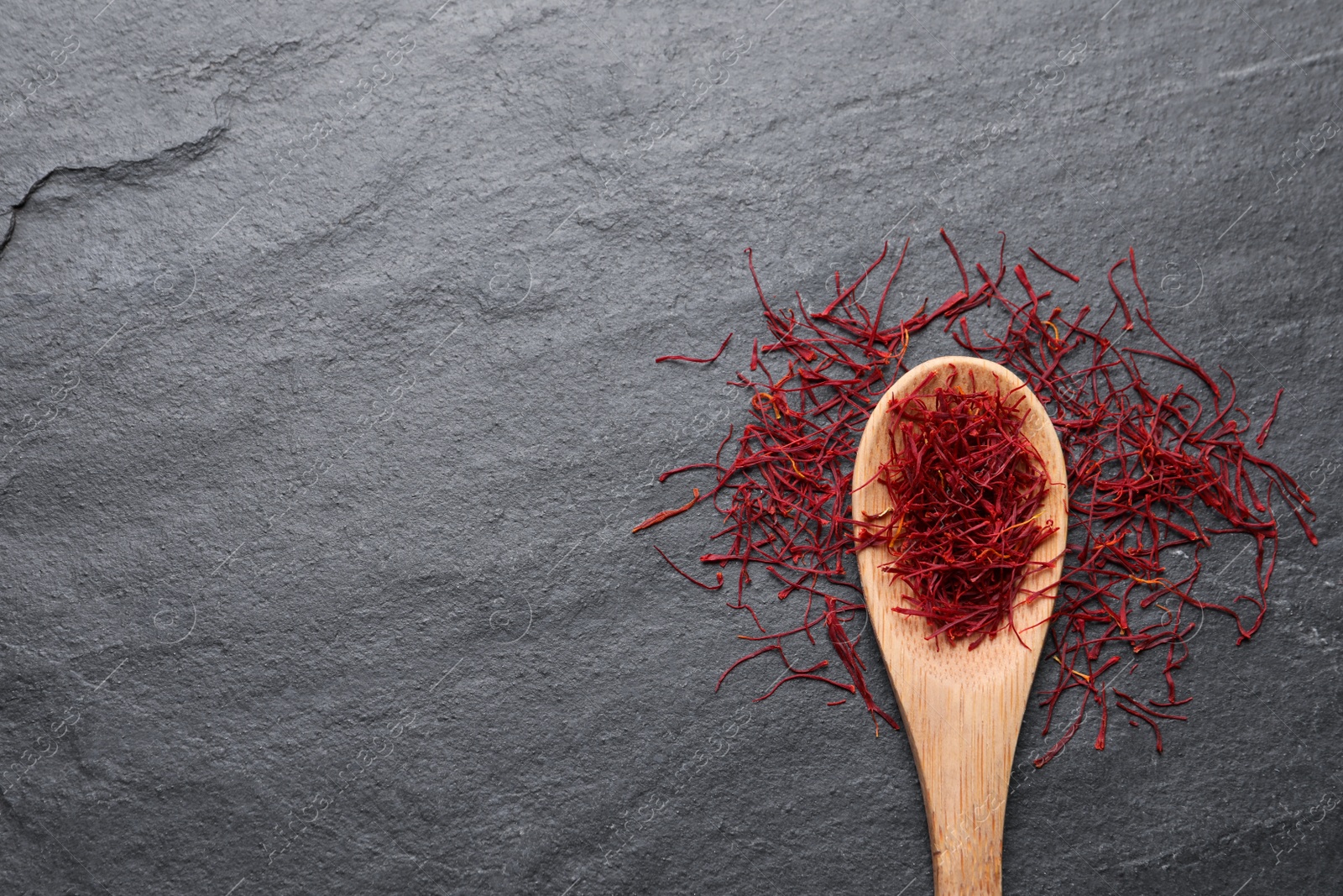 Photo of Dried saffron on grey table, flat lay. Space for text