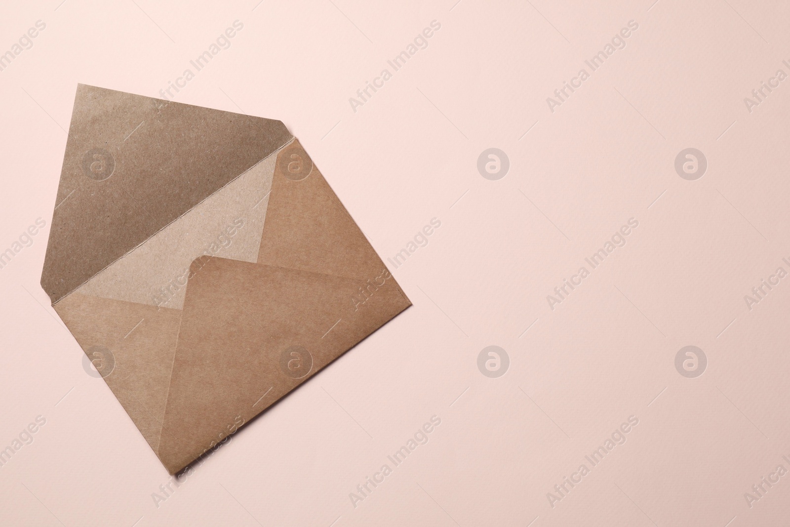 Photo of Letter envelope on beige background, top view. Space for text