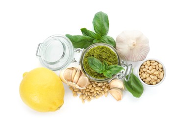 Photo of Delicious pesto sauce in jar and ingredients isolated on white, top view