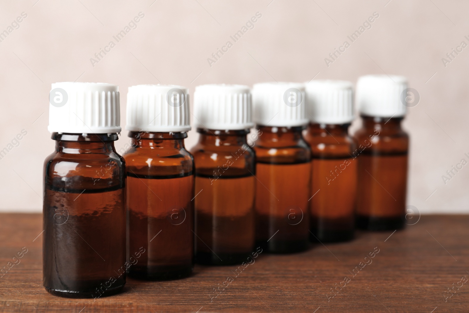 Photo of Glass bottles with essential oil on wooden table