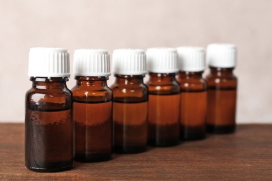 Photo of Glass bottles with essential oil on wooden table