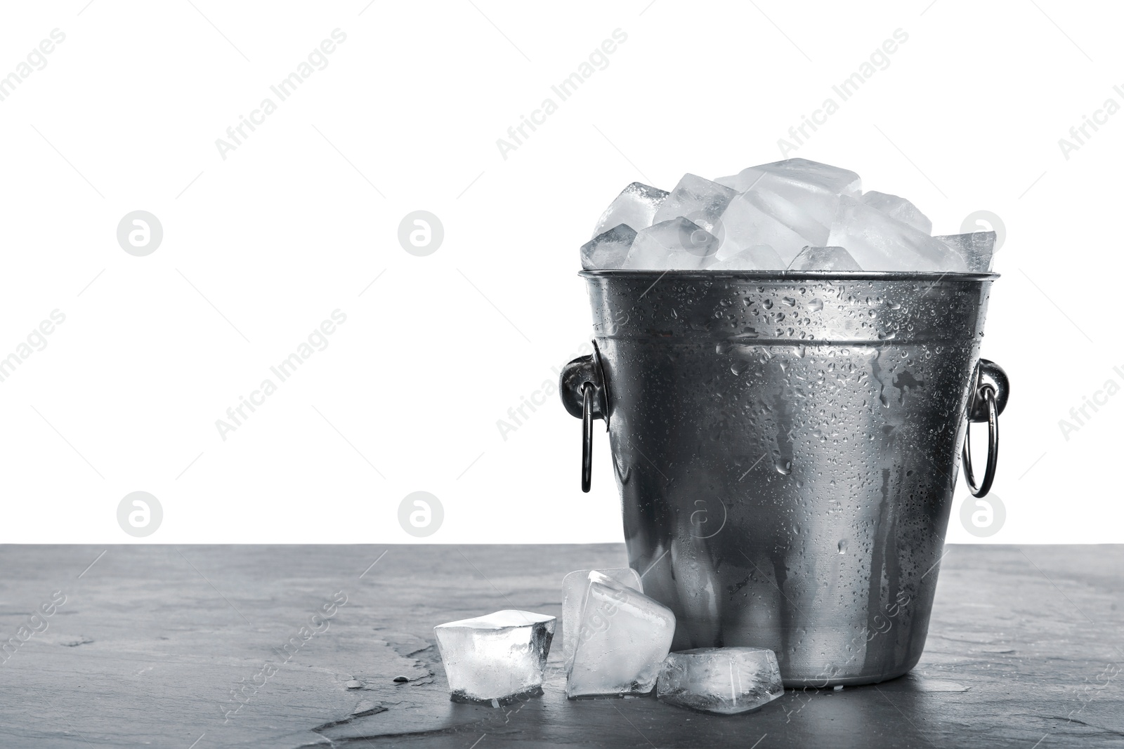 Photo of Metal bucket with ice cubes on table against white background