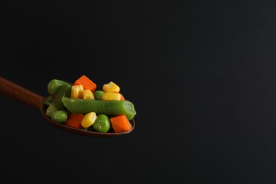 Fresh vegetables in spoon on black background, closeup. Space for text