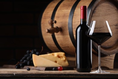 Photo of Delicious wine, cheese, grapes and wooden barrel on table against black background. Space for text