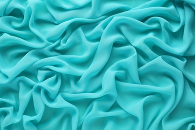 Photo of Beautiful turquoise tulle fabric as background, top view