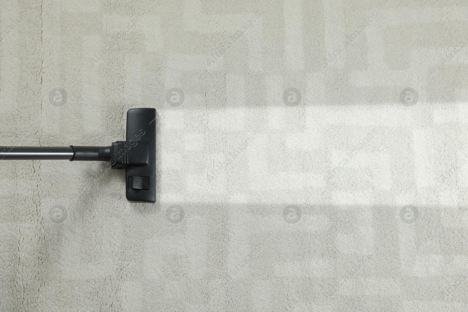 Image of Hoovering carpet with vacuum cleaner, top view and space for text. Clean trace on dirty surface