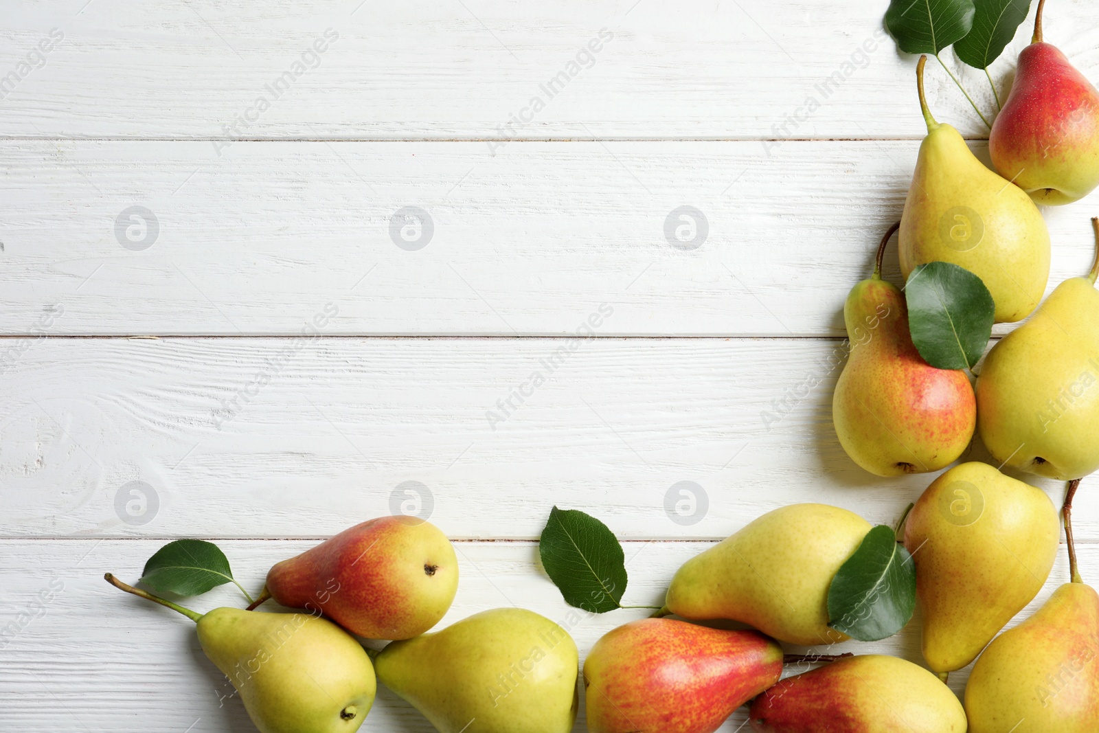 Photo of Flat lay composition with ripe pears on white wooden background. Space for text