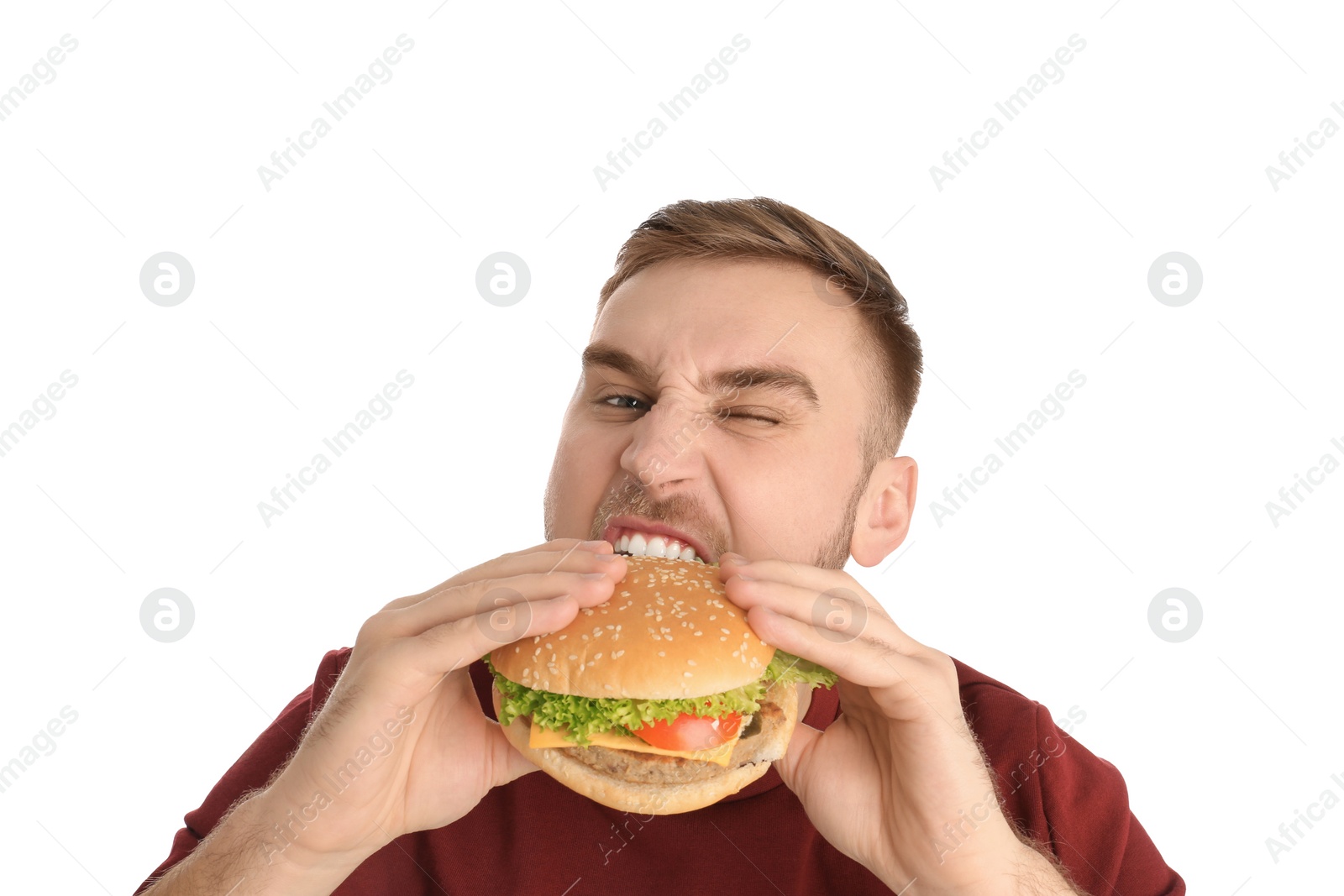 Photo of Young man eating tasty burger on white background