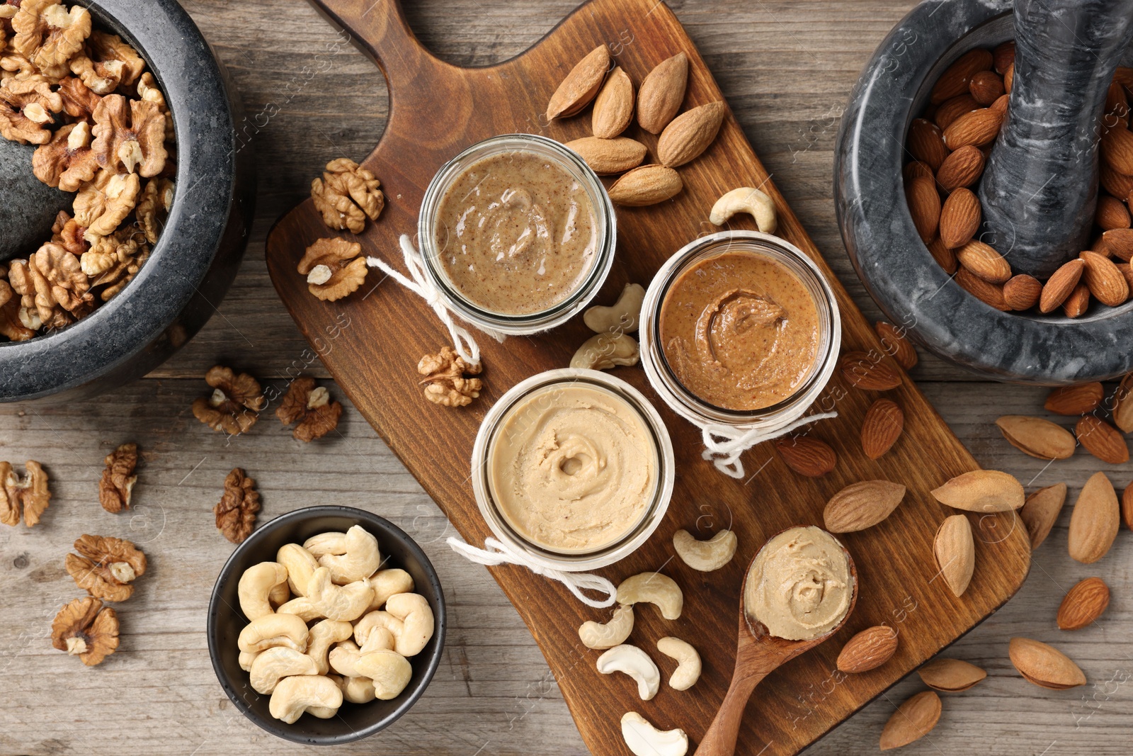 Photo of Making nut butters from different nuts. Fat lay composition on wooden table