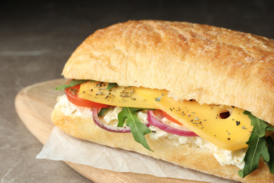 Photo of Delicious sandwich with fresh vegetables and cheese on grey table, closeup