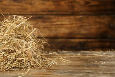 Photo of Heap of dried hay on wooden table. Space for text