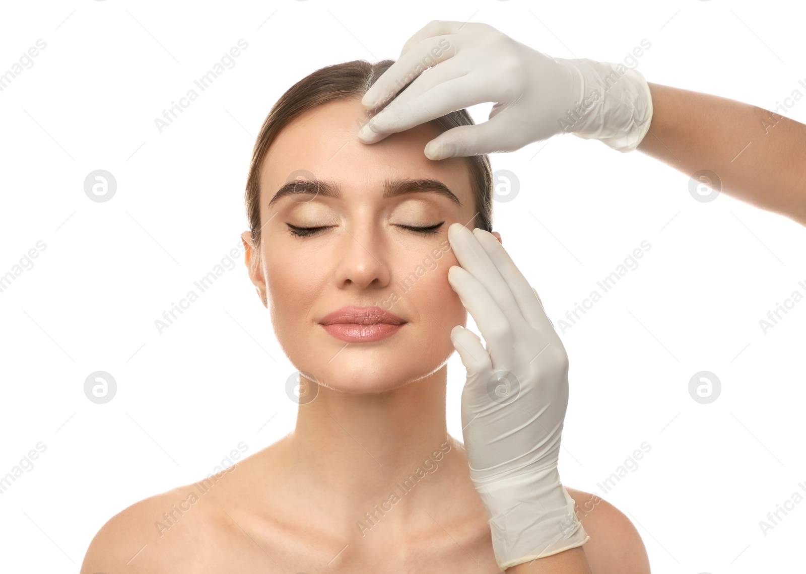 Photo of Doctor examining woman's face before plastic surgery on white background