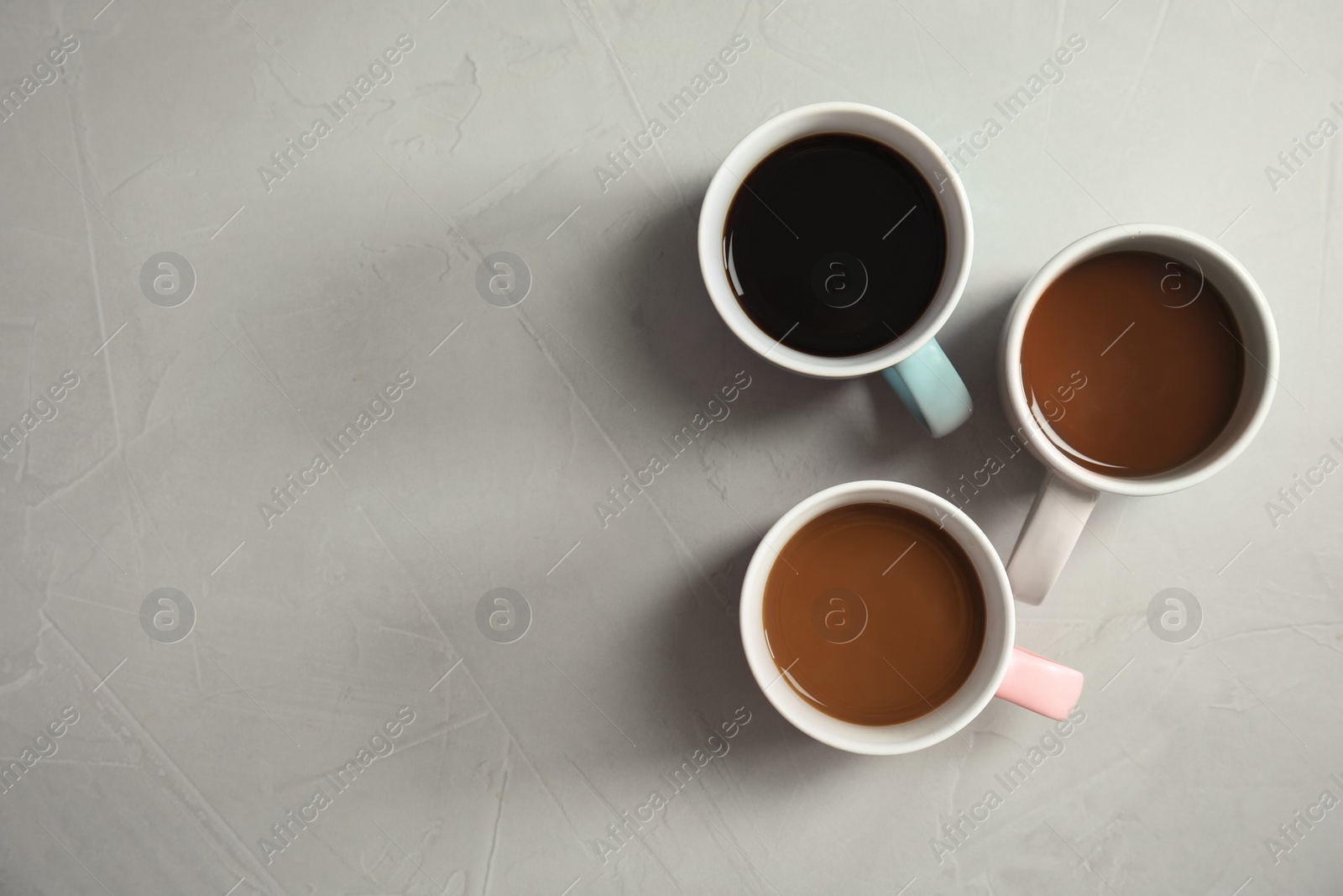 Photo of Flat lay composition with cups of coffee on gray background. Food photography