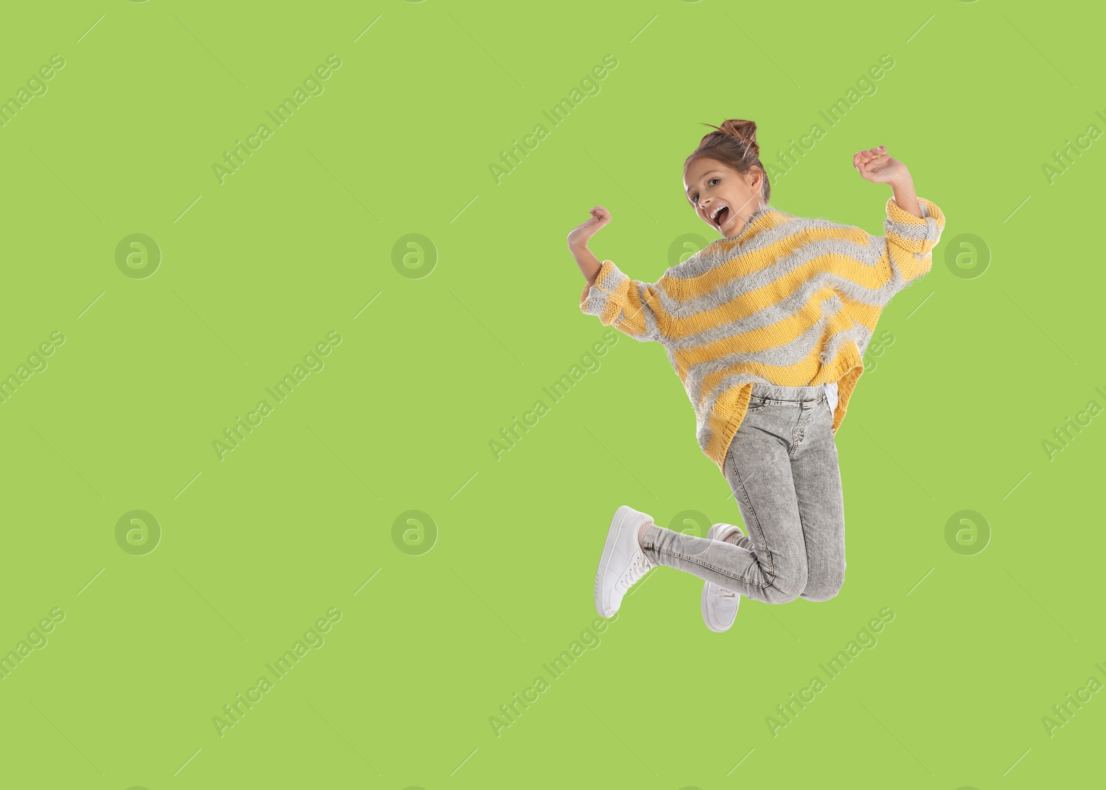 Image of Cute girl jumping on light green background, space for text