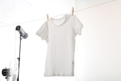 Photo of One t-shirt drying on washing line isolated on white