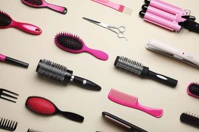 Photo of Flat lay composition of professional hairdresser tools on beige table