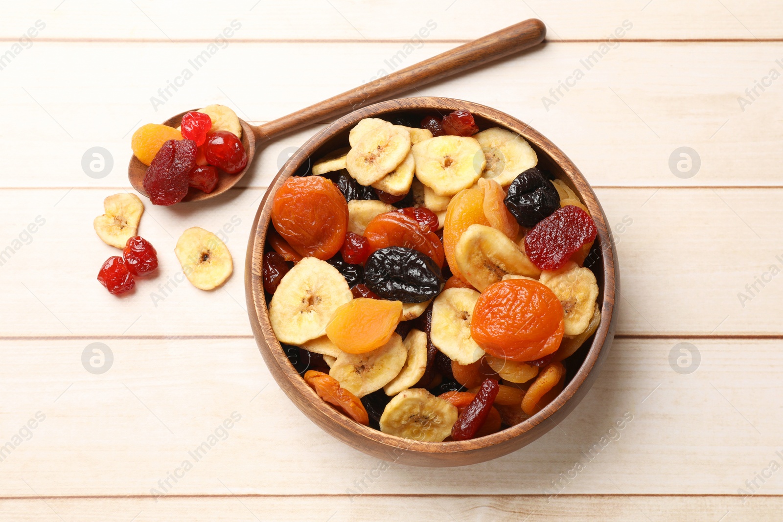 Photo of Mix of delicious dried fruits on white wooden table, flat lay