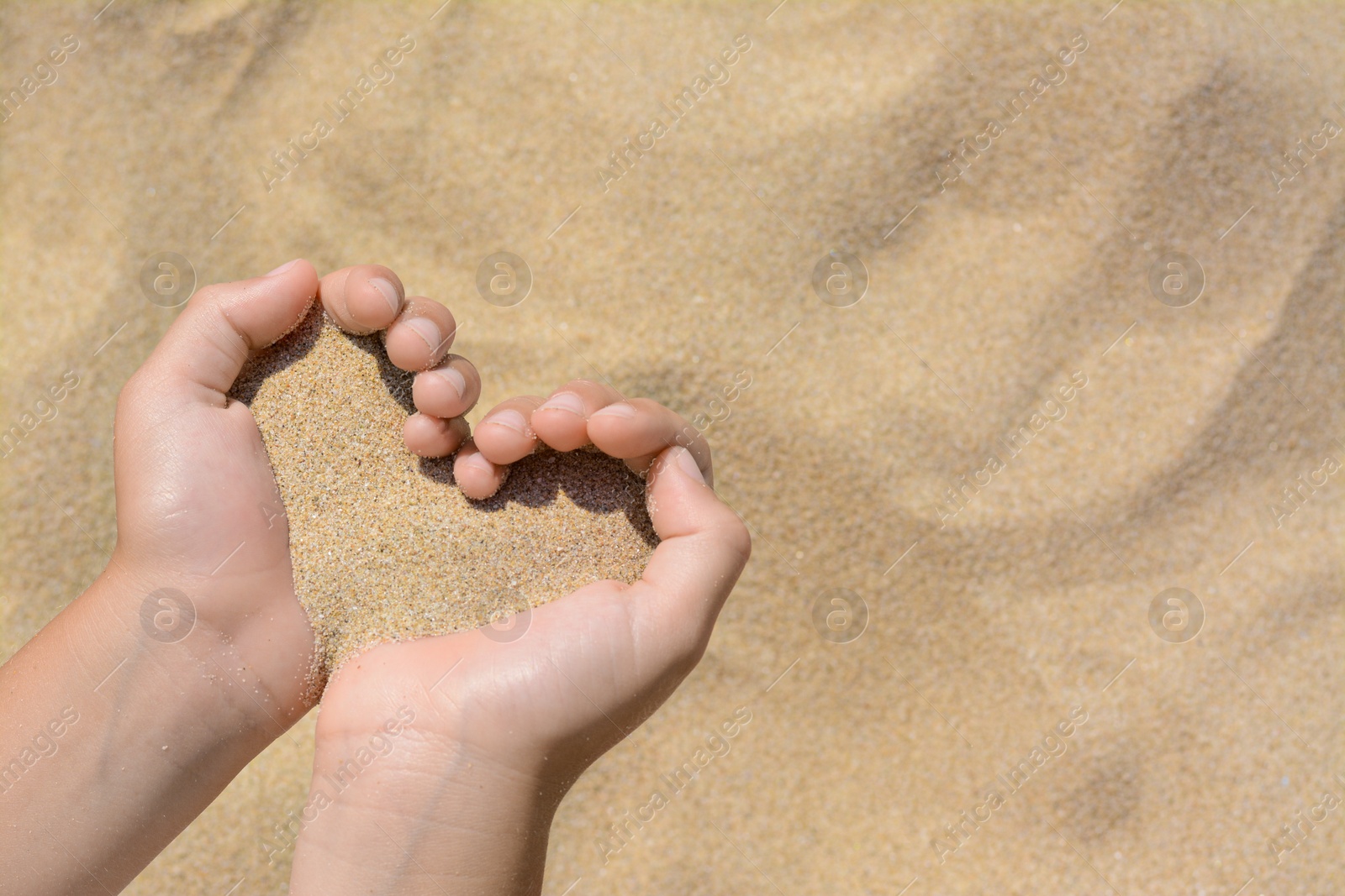 Photo of Child holding sand in hands outdoors, closeup with space for text. Fleeting time concept