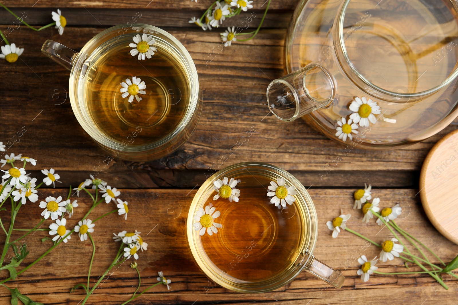 Photo of Flat lay composition with tea and chamomile flowers on wooden table