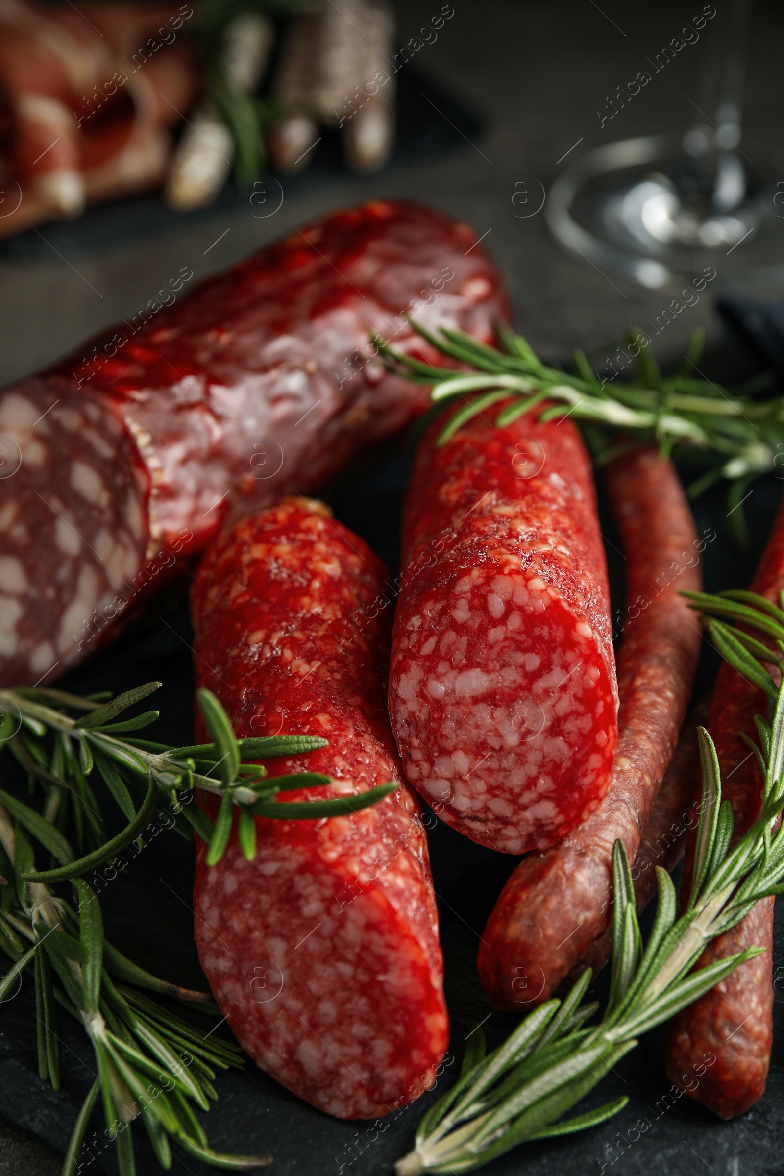 Photo of Different types of sausages with rosemary on table, closeup