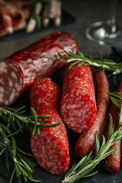 Different types of sausages with rosemary on table, closeup