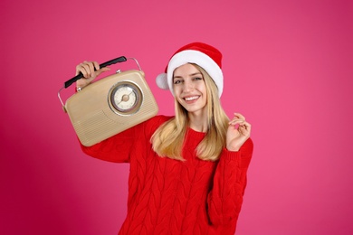 Happy woman with vintage radio on pink background. Christmas music