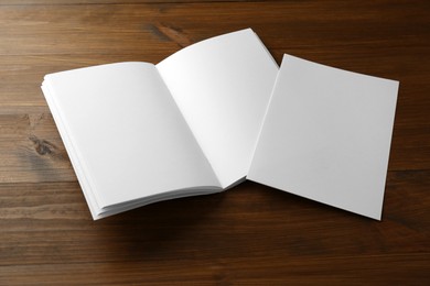 Sheet of paper and blank brochure on wooden table. Mockup for design