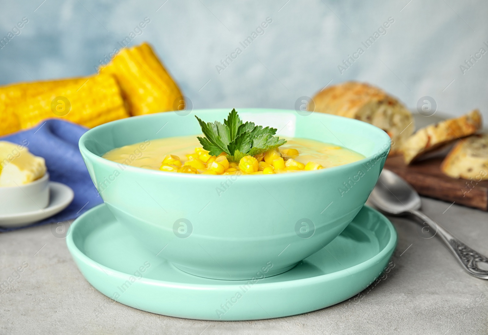 Photo of Delicious corn cream soup served on light grey table