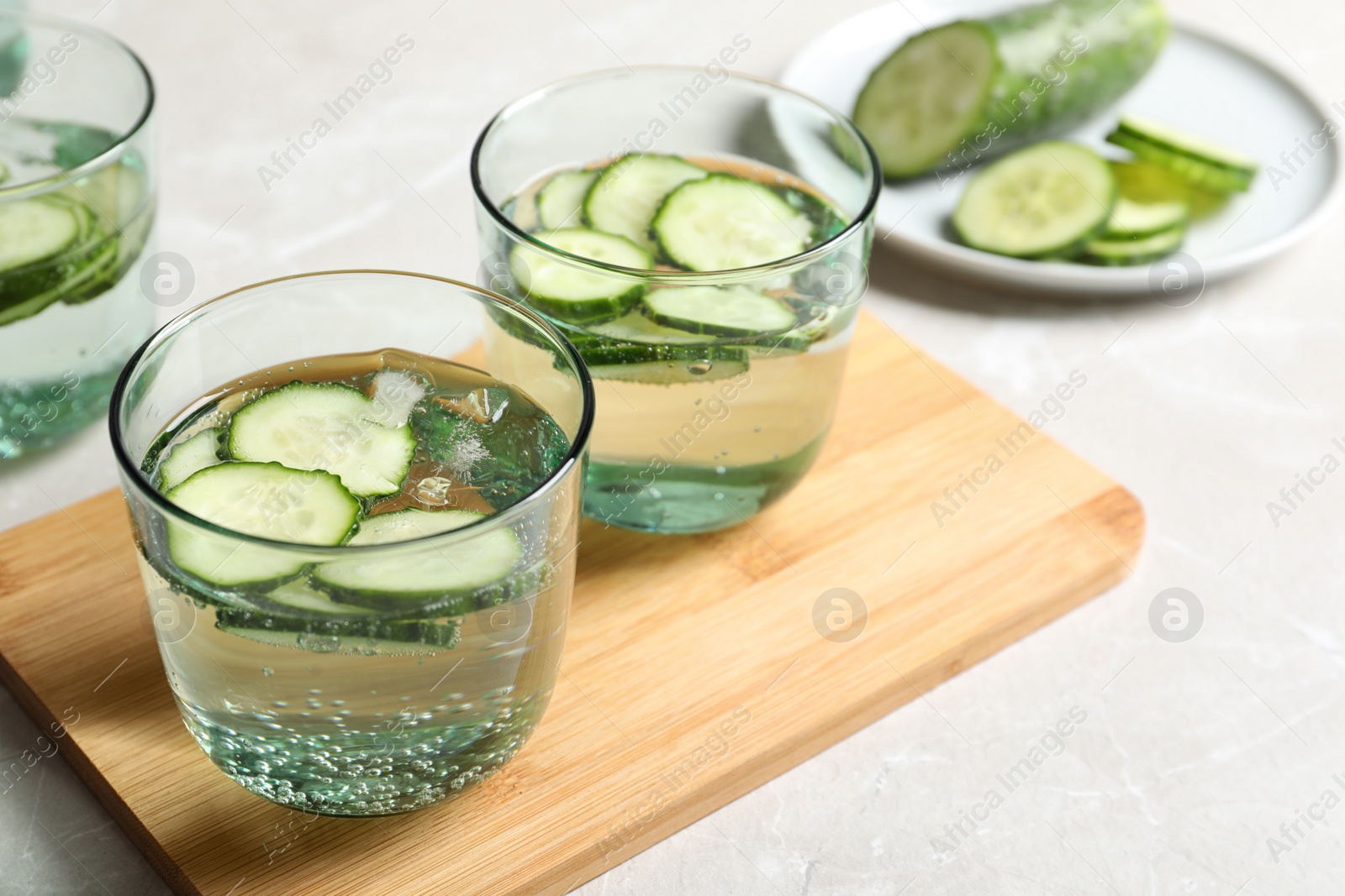 Photo of Glasses of fresh cucumber water on table. Space for text