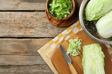 Fresh Chinese cabbages and knife on wooden table, top view. Space for text