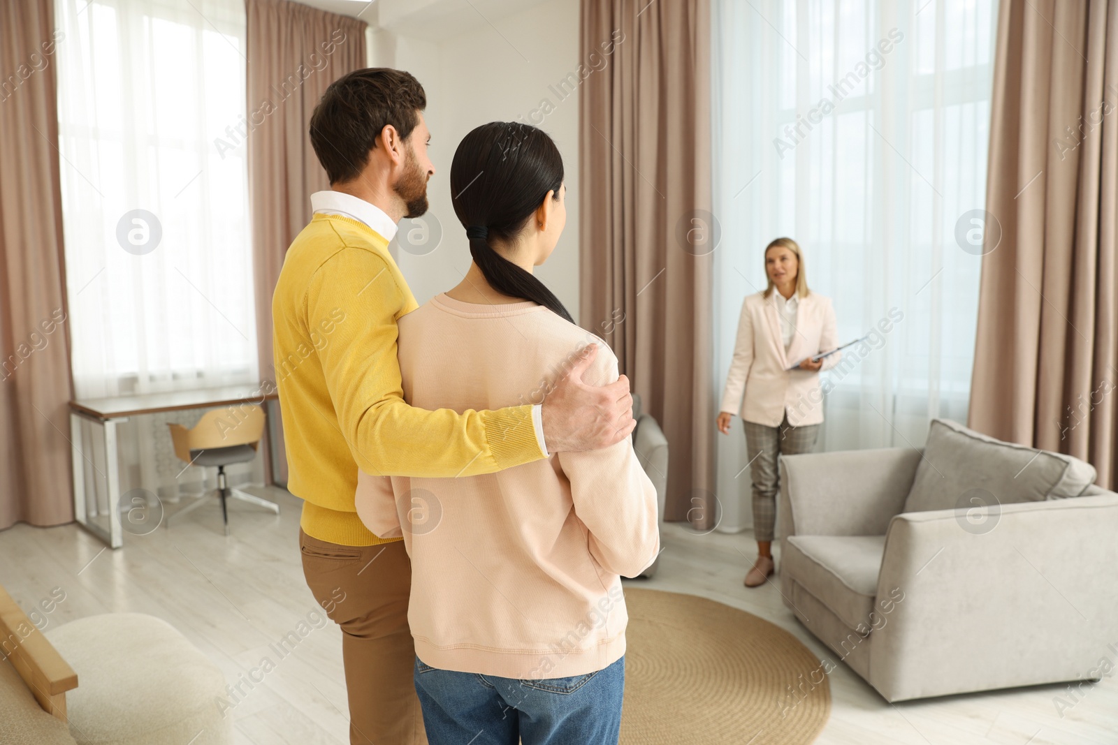 Photo of Real estate agent showing new apartment to couple