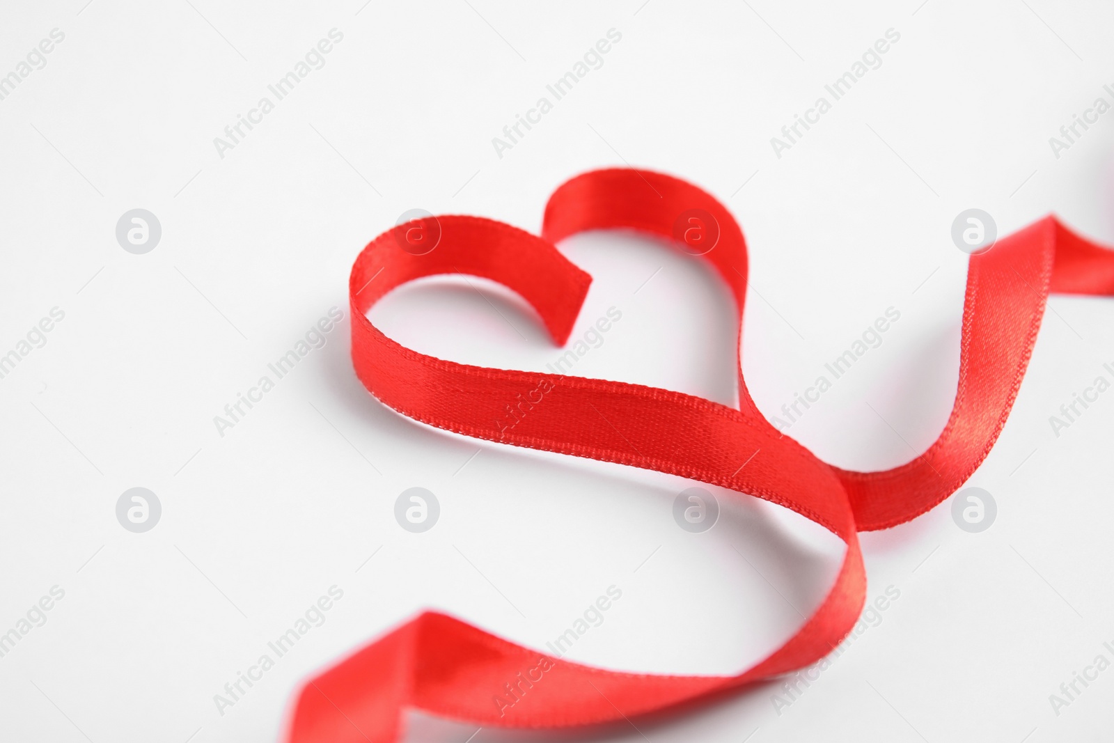 Photo of Heart made of red ribbon on white background. Valentine's day celebration