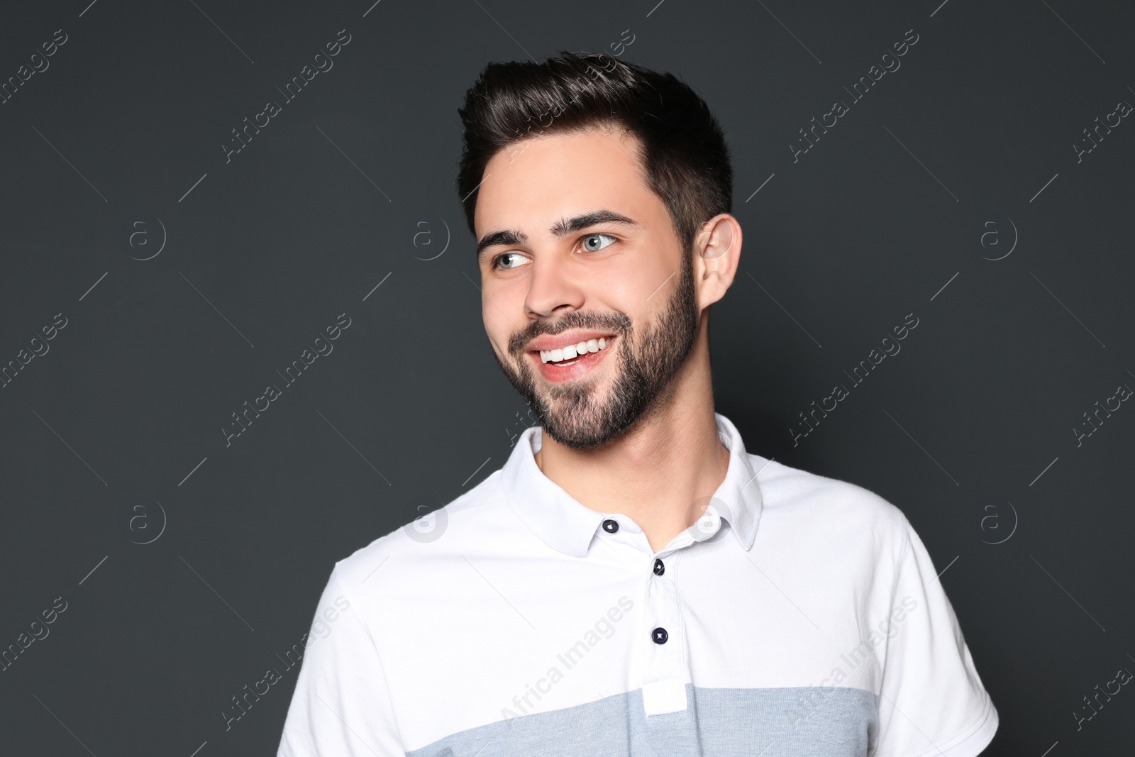 Photo of Portrait of handsome smiling man on grey background