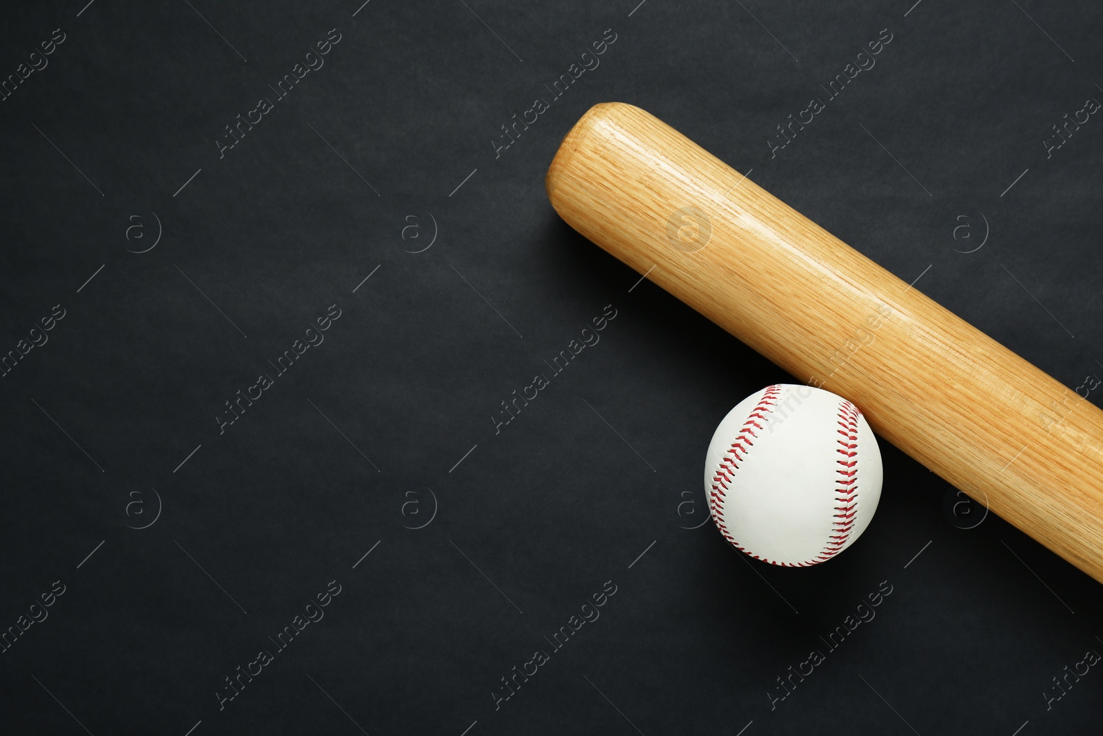 Photo of Wooden baseball bat and ball on black background, flat lay. Space for text