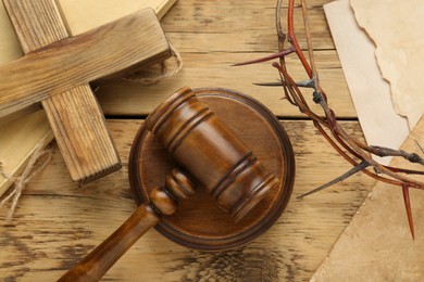 Judge gavel, cross and crown of thorns on wooden table, flat lay