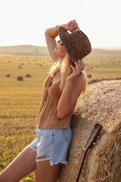 Happy hippie woman near hay bale in field